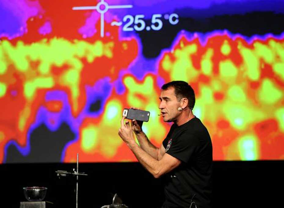 A man presenting infront of a large screen