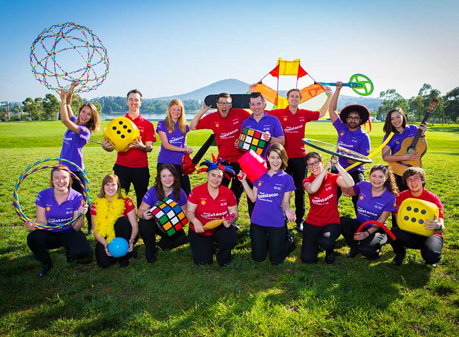 A group of people holding a collection of science props