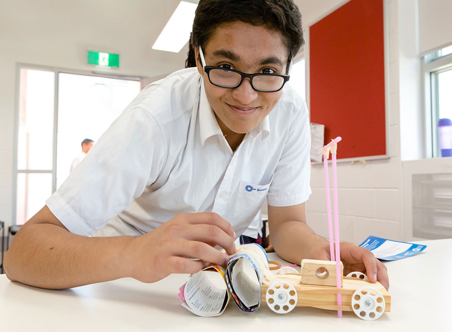 A student building a model car with a crumple zone