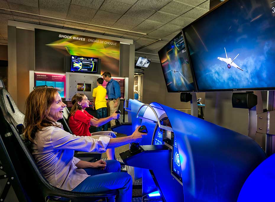 People playing with a flight simulation machine.