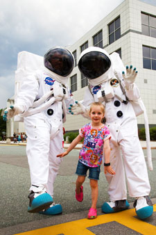 Two astronauts and a young child outside Questacon