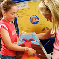 two young girls interacting with a science exhibition