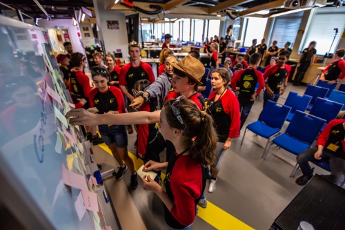 Delegates busily brainstorming around a whiteboard