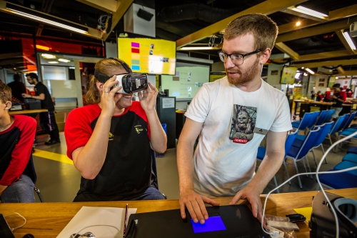 A delegate tests her prototype using a VR headset