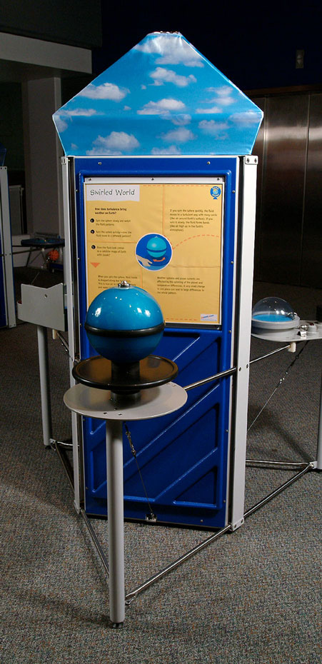 Turbulence in Earth's atmosphere causes weather patterns. A exhibit with a blue and black sphere at the front and a yellow and blue information panel at the rear.