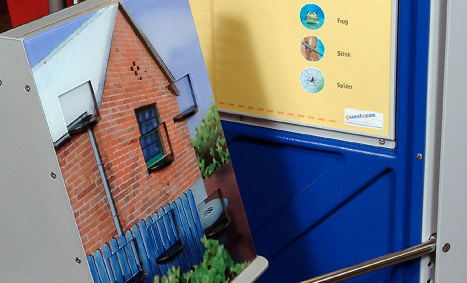 Look for six animals in the suburban scene. See if you can find the same six animals in the bush scene. An exhibit with a yellow and blue information panel at the back and a triangular prism with a picture of house at the front.