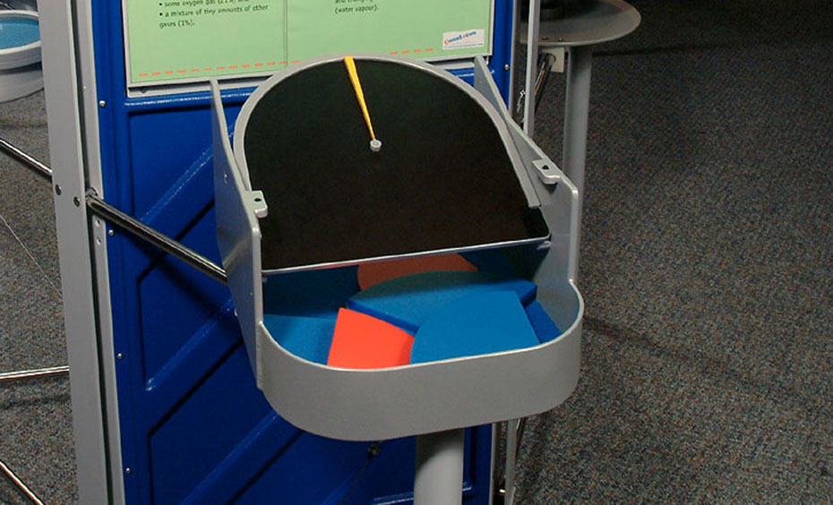 Place puzzle pieces representing proportions of gases within the pie chart. A green, blue and grey exhibit.