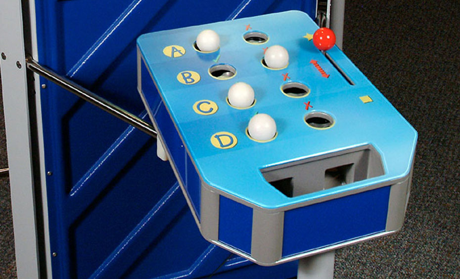 Read the quiz questions and place a ball against the response that you think is correct, then check your answers when the balls fall through or stay in place. A blue horizontal table with white balls, a red lever and the letters 'A', 'B', 'C' and 'D' displayed.