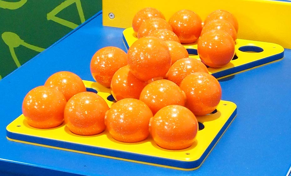 How do the balls fit together differently in each type of pyramid? On a blue surface are a triangle shaped and a rectangle shaped yellow flat base, on which sits piles of orange balls.