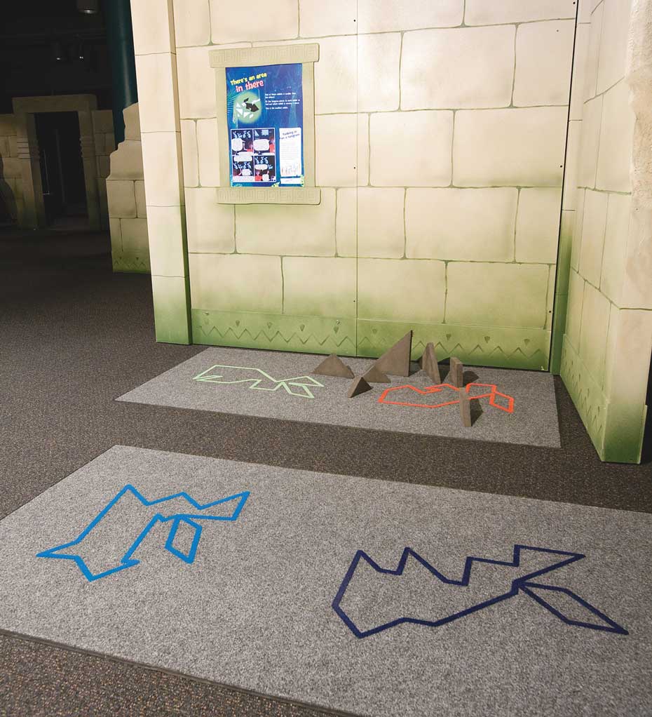 The area of an irregular shape can be calculated by measuring its component shapes. A carpeted area in which there are four abstract rabbit shapes on the carpet. In the background is a fake stone wall with a blue, white and green information panel.