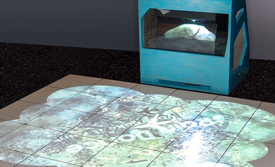 Use your feet to 'collect' animated raindrops projected onto the floor, until enough water has accumulated to cause rainfall. White tiles on the floor have circular light projection onto them, from a blue box at the back of the tiles.
