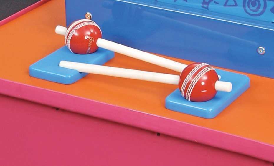 Compare whether it's easier to balance a ball on a stick in the air or in the palm of your hand. A pink and orange display table with a vertical blue information panel on top. In front of the panel, are two red cricket balls which each have a shite stick going through them.