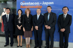 4 men and 2 women all dressed in dark business dress are standing in front of a purple background with the words 'The Questacon-Japan Relationship'