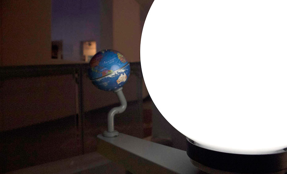A model Earth can be moved in orbit around a model Sun to show how Earth's tilt and angle of sunlight hitting Earth causes seasons. A model earth and sun showing shadows on the earth.