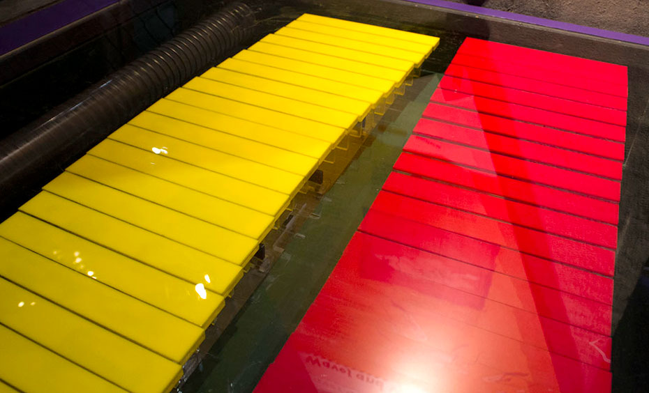 A yellow and red series of horizontal rods under a glass display.