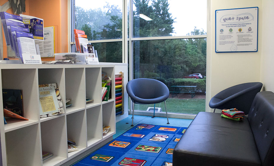 Quiet Space is removed from the main Mini Q galleries, and contains a few chairs and book resources for reading and reflection. A light lit room with a bookshelf and books, a play rug, a leather couch, two seats and a window looking to the outside garden.