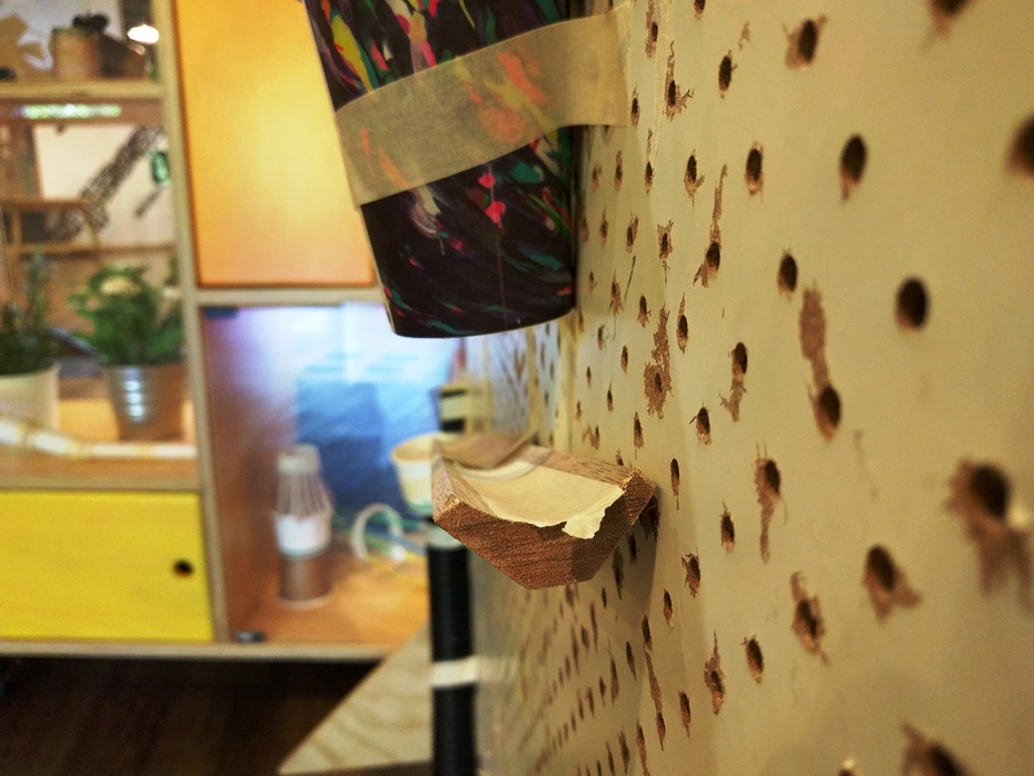 Close-up of a piece of skirting board stuck to a sheet of pegboard