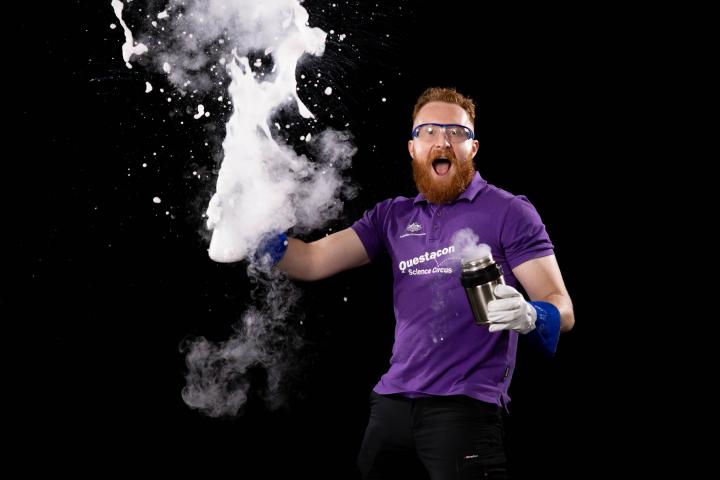 Man in purple shirt with exploding foam in hand