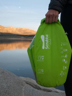A traveller holds Scrubba Wash Bag in the wilderness