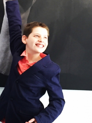 Hamish young app developer poses in front of a banner 