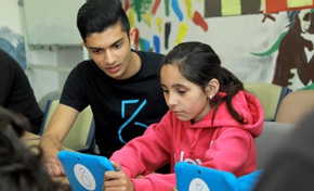 Taj Pabari, founder of Fiftysix Creations, works with a student