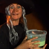 A witch holding a tub of green slime.