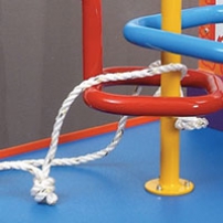 An orange and blue exhibit table. Red yellow and blue steel bars rise out of the table top, and are bent into different shapes. A piece of white rope with a knot in it is threaded between the bars.