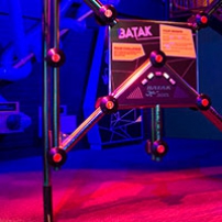 A large stainless steel square shape with cross beams from each corner, and light buttons mounted through the steel work.