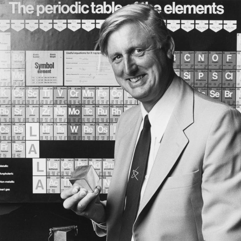 Founder Mike Gore in front of a periodic table of elements