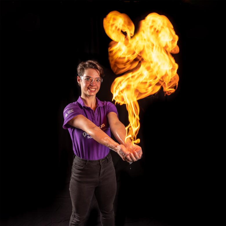 An experienced Questacon Science Circus presenter safely handling a ball of fire