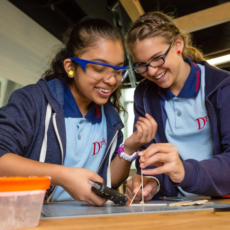 Two girls wearing safety glasses