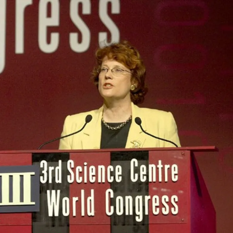 Annie speaks at a podium which reads, "third science centre world congress".