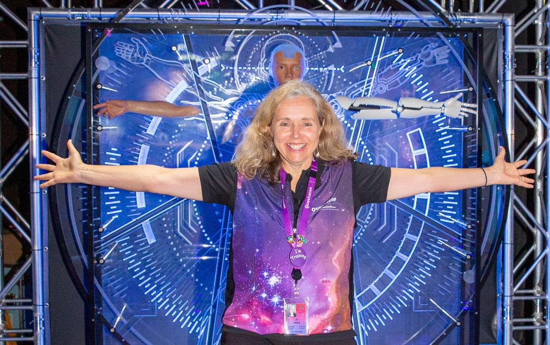Director Jo White in the Born or Built exhibition with her arms outstretched
