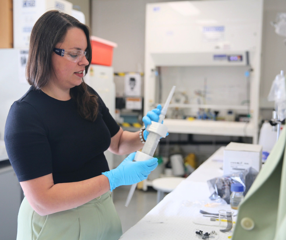 Dr Katrina Wruck in a labratory holding a scientific instrument that holds water